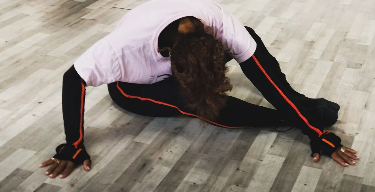 Danseuse en étirement au sol dans un studio de danse