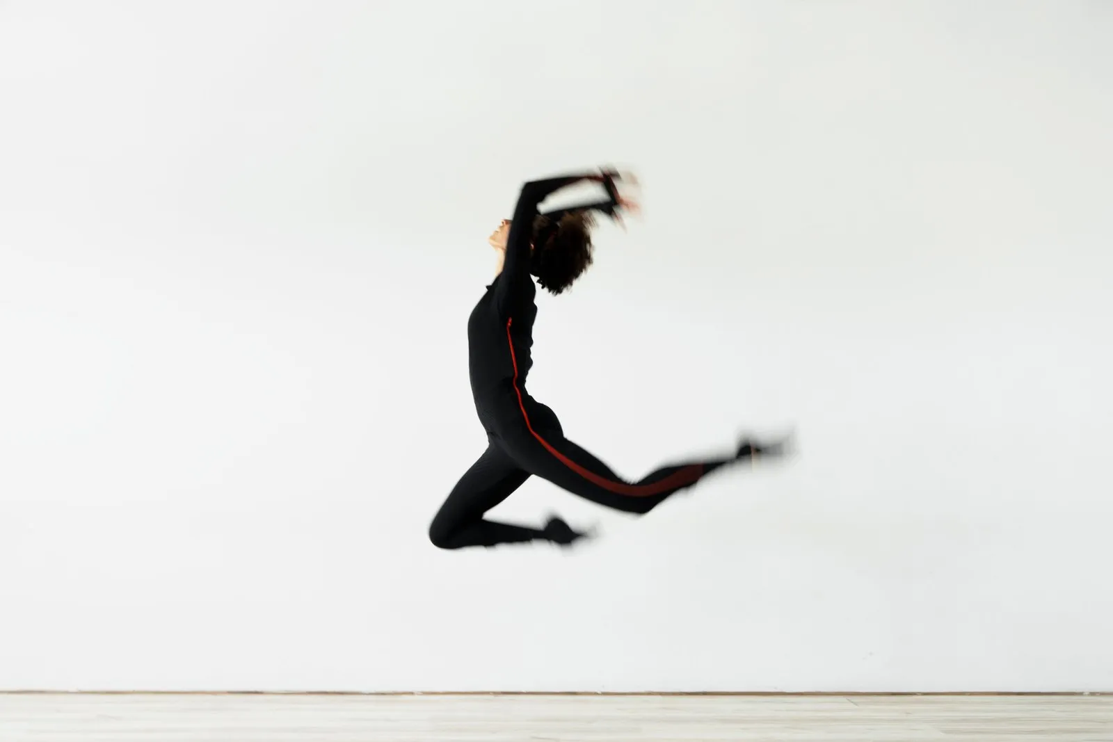 Danseuse en combinaison de motion capture en pleine détente au saut