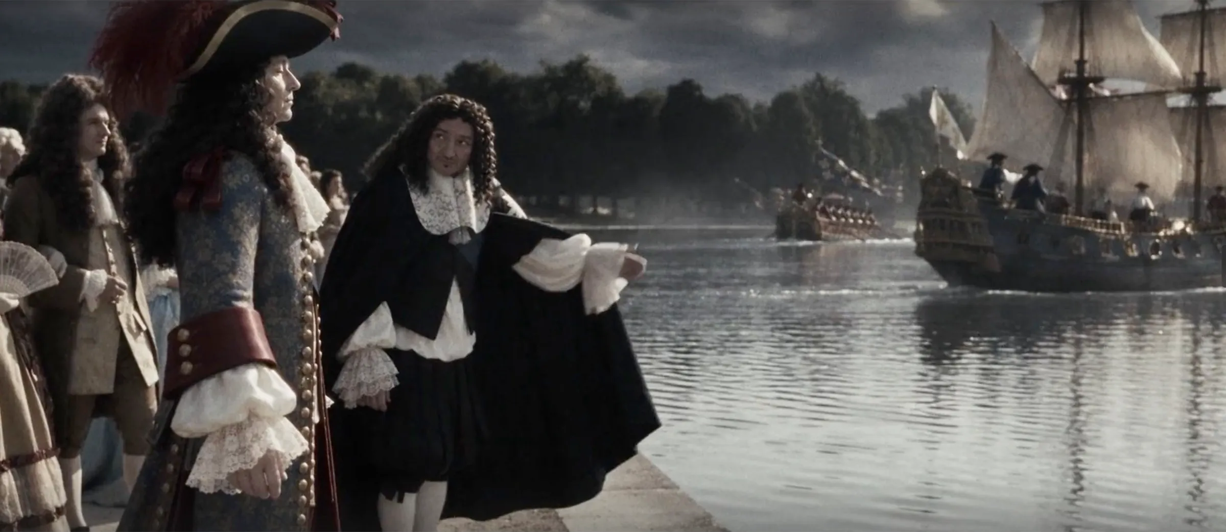 Reconstitution du XVIIe siècle : des personnages de cour au bord d’un canal, une flottille de navires à voile en arrière-plan